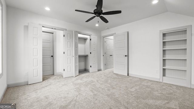 unfurnished bedroom featuring lofted ceiling, light colored carpet, and ceiling fan