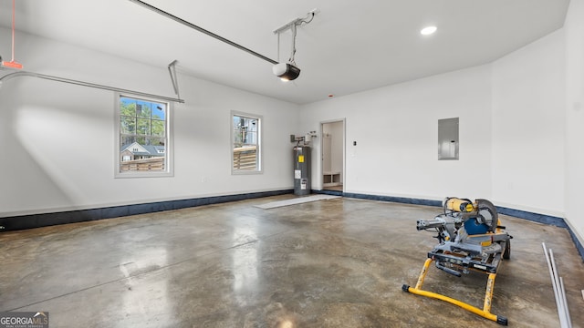 garage with a garage door opener, electric water heater, and electric panel