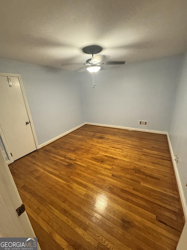 unfurnished room with hardwood / wood-style flooring, ceiling fan, and a textured ceiling