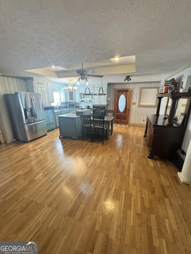 interior space with an inviting chandelier, sink, light hardwood / wood-style flooring, and a textured ceiling