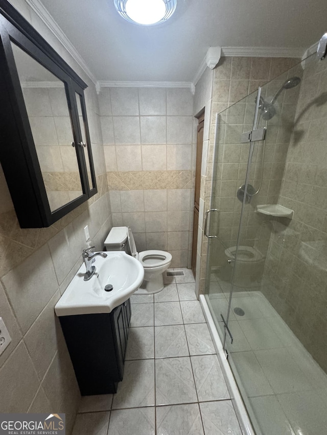 bathroom featuring toilet, a shower with shower door, crown molding, tile walls, and vanity