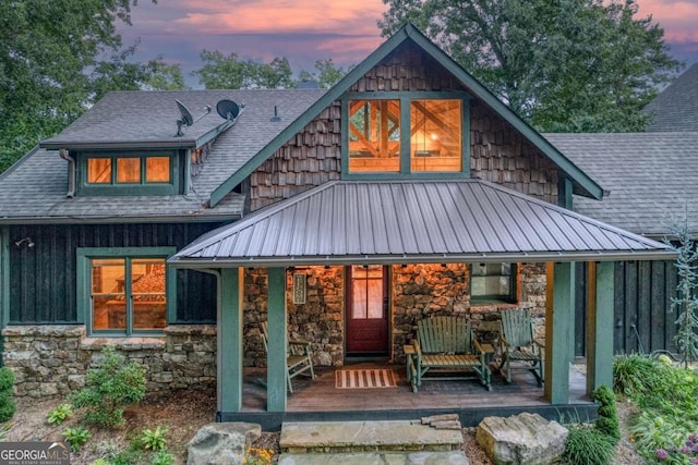 back house at dusk with a porch