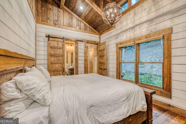 bedroom featuring wood ceiling, lofted ceiling, a barn door, and wood walls