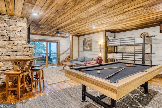 game room featuring wood ceiling, ceiling fan, wood-type flooring, and wood walls