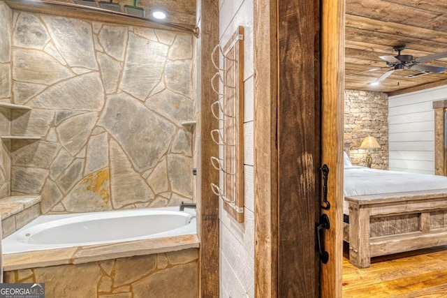 bathroom with wood ceiling, ceiling fan, wood-type flooring, and tiled bath