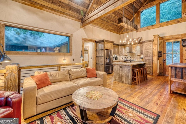 living room with sink, wood ceiling, high vaulted ceiling, light hardwood / wood-style flooring, and beamed ceiling