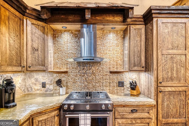 kitchen with wall chimney exhaust hood, high end stainless steel range, and decorative backsplash