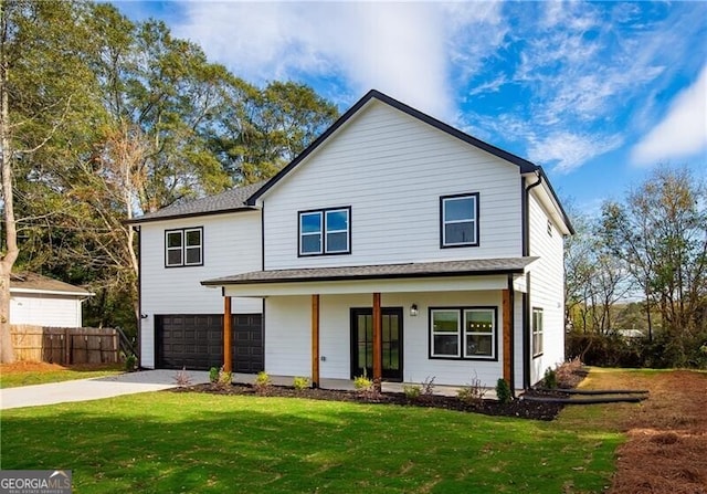 view of front of home featuring a garage, a front yard, and a porch