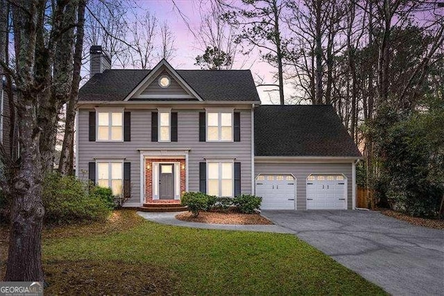 view of front of house with a garage and a lawn