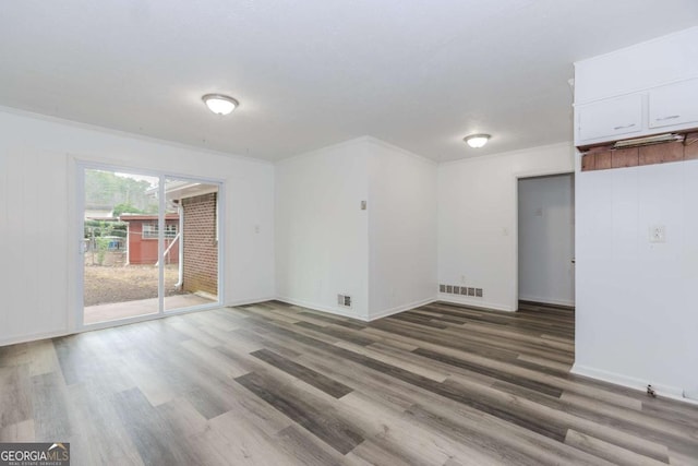 spare room featuring crown molding and hardwood / wood-style floors