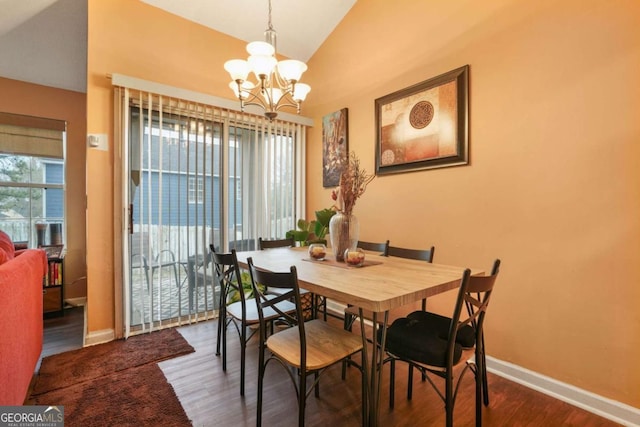 dining space featuring an inviting chandelier, hardwood / wood-style floors, and vaulted ceiling