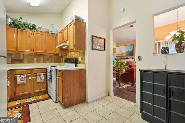 kitchen with a chandelier, hanging light fixtures, light tile patterned floors, electric range, and backsplash