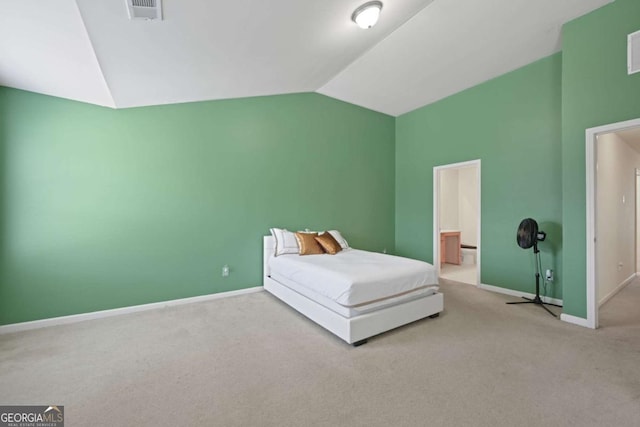 unfurnished bedroom with light colored carpet, vaulted ceiling, and ensuite bath