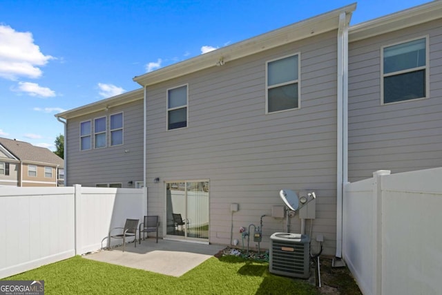 rear view of property with central AC, a patio, and a lawn