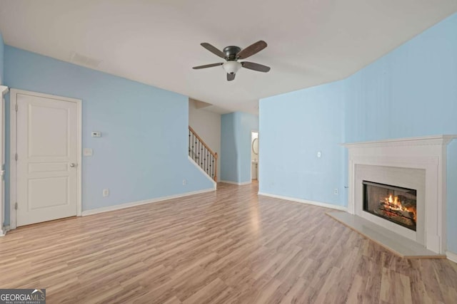 unfurnished living room with ceiling fan and light hardwood / wood-style flooring