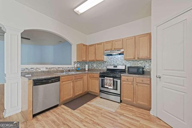 kitchen featuring appliances with stainless steel finishes, light brown cabinetry, tasteful backsplash, sink, and light wood-type flooring