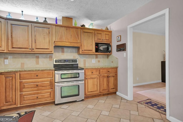 kitchen featuring decorative backsplash, light stone countertops, range with two ovens, and a textured ceiling