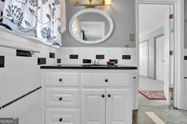 bathroom featuring vanity and backsplash