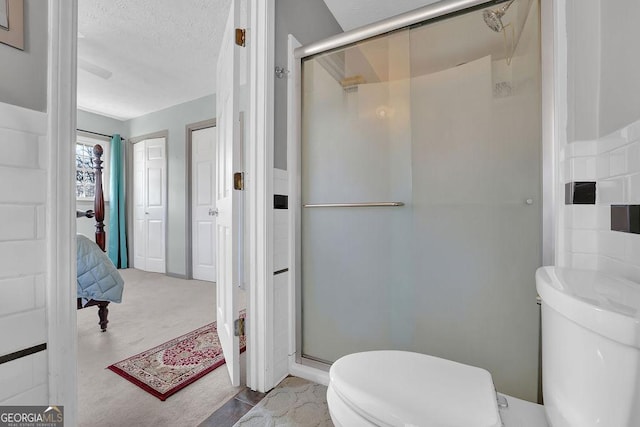 bathroom with an enclosed shower, a textured ceiling, and toilet