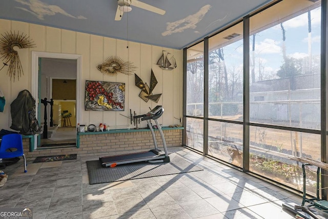 workout room with ceiling fan, floor to ceiling windows, and tile patterned flooring