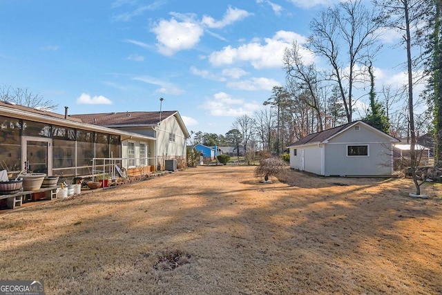 view of yard with central AC unit and a sunroom