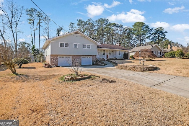 split level home featuring a garage and a front lawn