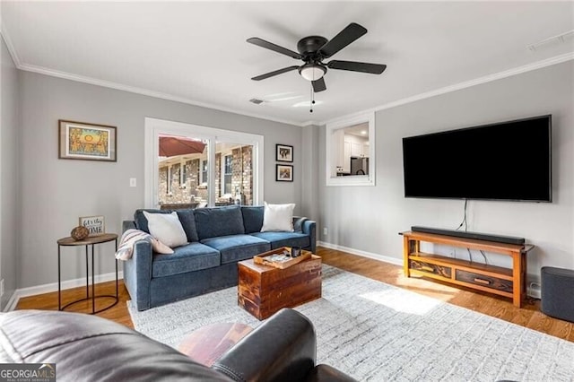 living room with ornamental molding and light hardwood / wood-style floors