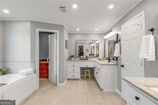 bathroom with vanity, hardwood / wood-style floors, crown molding, and a bath