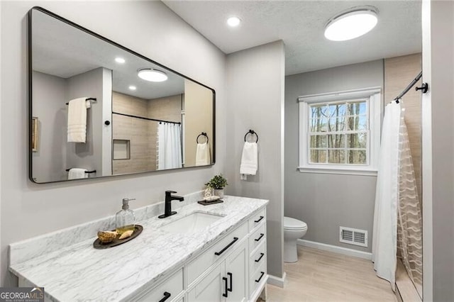 bathroom with walk in shower, vanity, toilet, and hardwood / wood-style floors