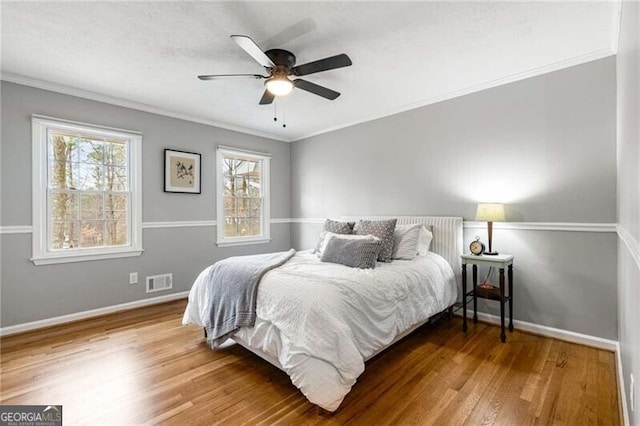 bedroom featuring crown molding, hardwood / wood-style flooring, and ceiling fan