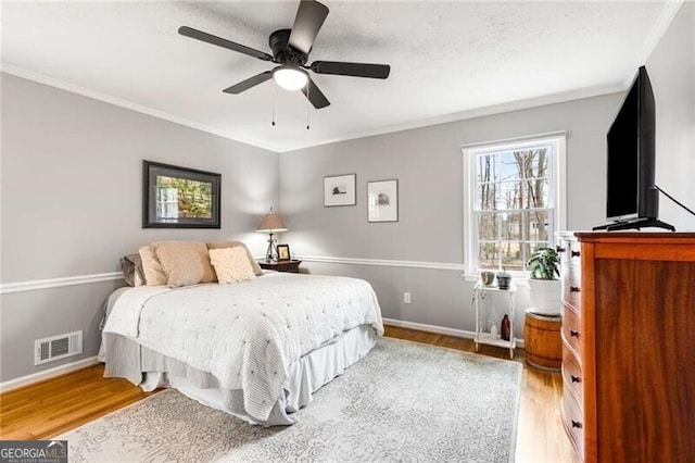 bedroom featuring crown molding, hardwood / wood-style floors, and ceiling fan