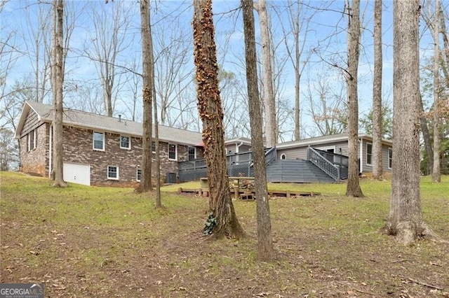 exterior space featuring a wooden deck and a lawn