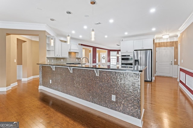 kitchen featuring decorative light fixtures, a breakfast bar area, white cabinets, and stainless steel refrigerator with ice dispenser