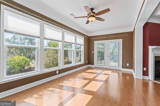 unfurnished living room with ornamental molding, light hardwood / wood-style floors, french doors, and ceiling fan