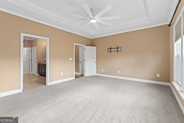 unfurnished bedroom featuring light carpet, ornamental molding, ceiling fan, and ensuite bathroom