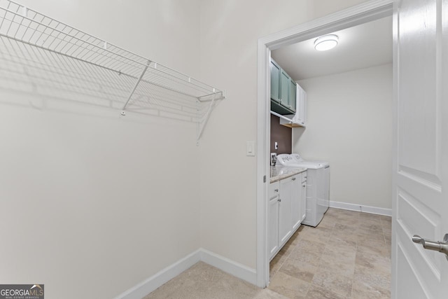 washroom featuring cabinets and independent washer and dryer