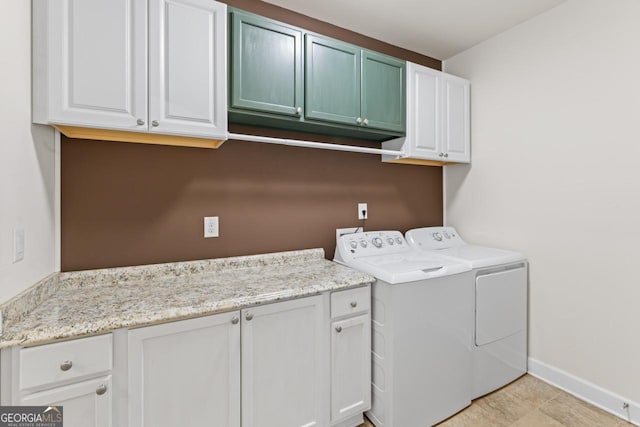 laundry area with washer and dryer, light tile patterned floors, and cabinets