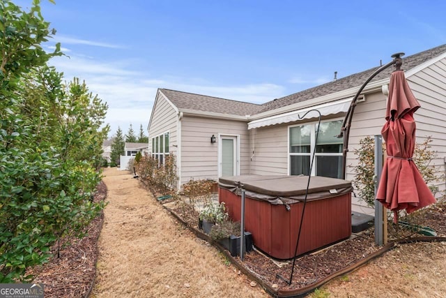 rear view of property with a hot tub