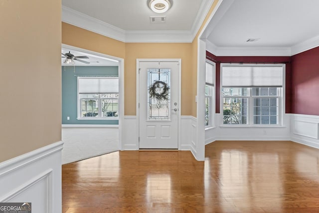 entryway featuring ornamental molding and light hardwood / wood-style flooring