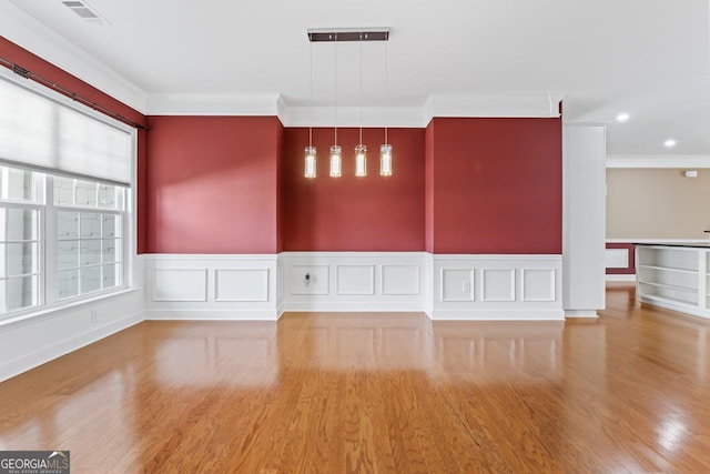 spare room with hardwood / wood-style flooring and ornamental molding