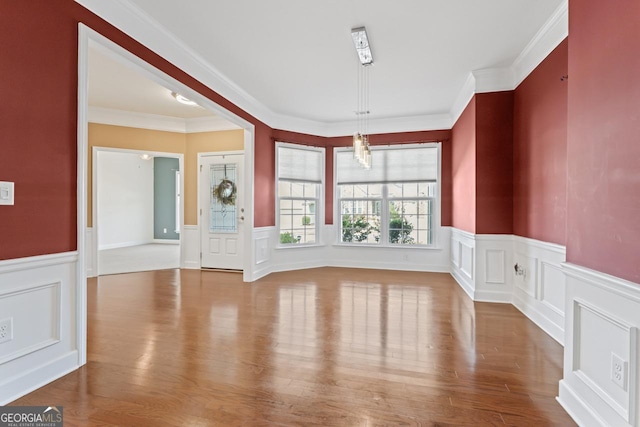 interior space with ornamental molding and hardwood / wood-style floors