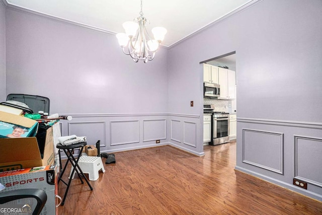 interior space with hardwood / wood-style flooring, crown molding, and a chandelier