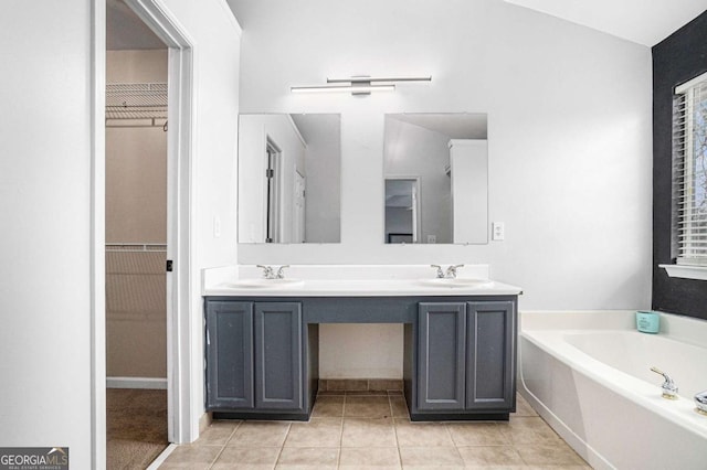 bathroom with vanity, tile patterned flooring, and a washtub