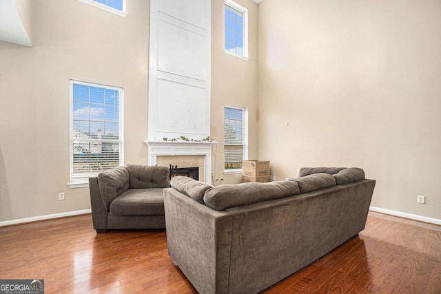 living room with wood-type flooring and a towering ceiling