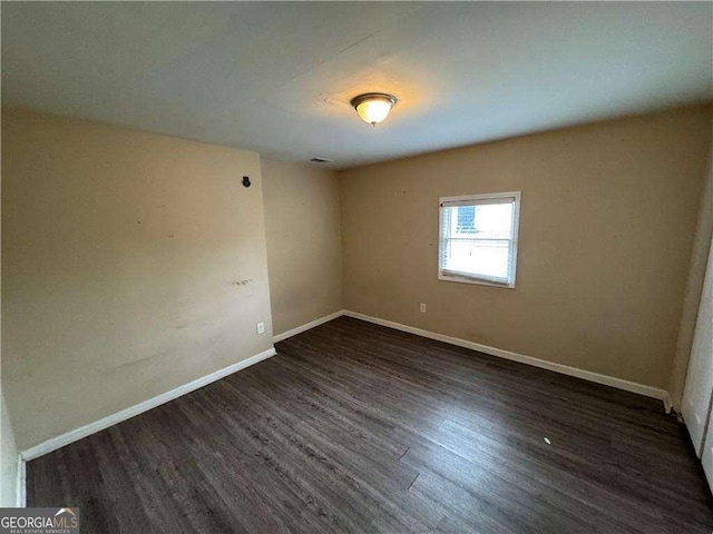 spare room with dark hardwood / wood-style flooring