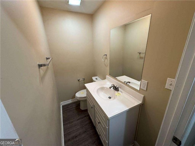 bathroom featuring vanity, hardwood / wood-style floors, and toilet