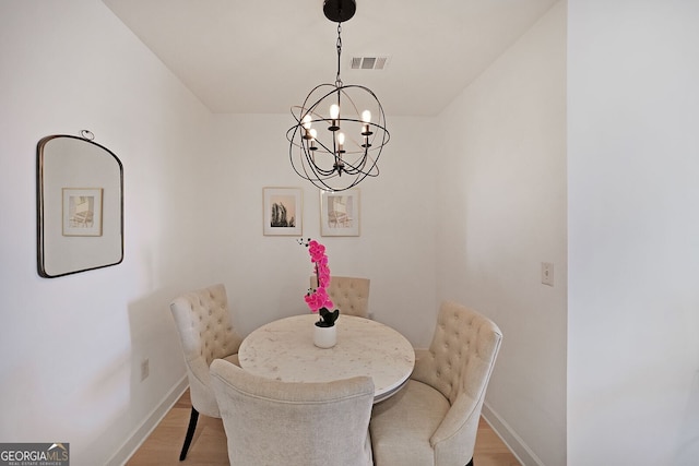 dining area featuring an inviting chandelier and light wood-type flooring