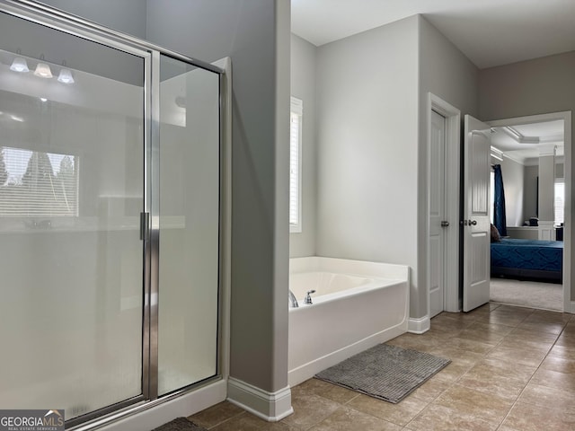 ensuite bathroom featuring a stall shower, baseboards, ensuite bath, a garden tub, and tile patterned flooring