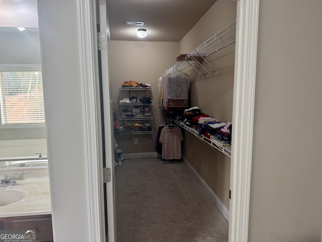 walk in closet featuring carpet flooring, a sink, and visible vents