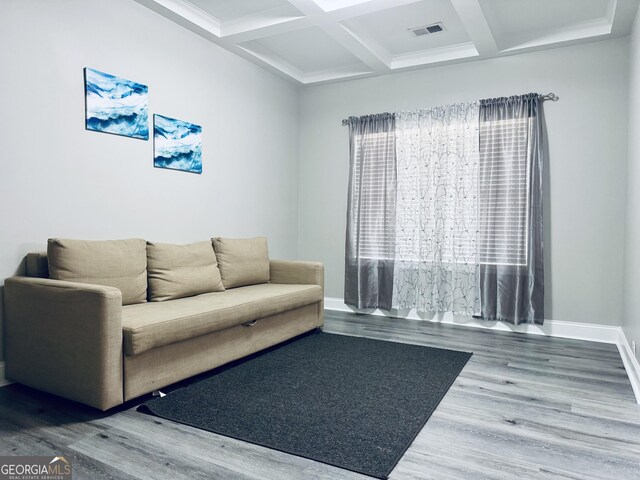 living area with coffered ceiling, visible vents, beamed ceiling, and wood finished floors